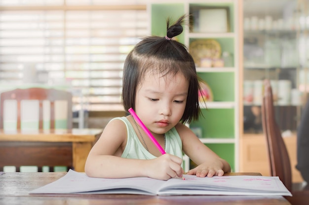 写真 テーブルに座っている女の子が目をそらしている