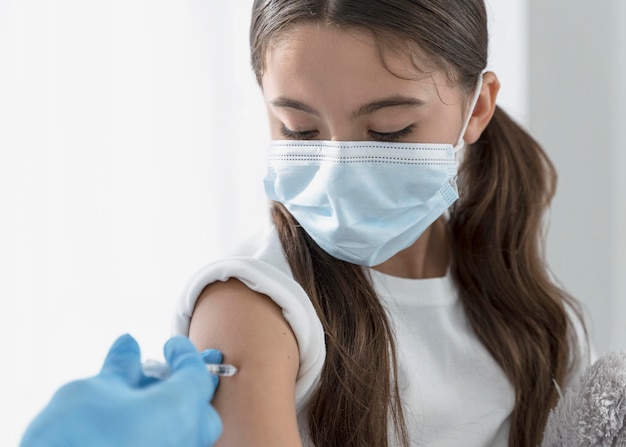 Girl looking down as she is vaccinated