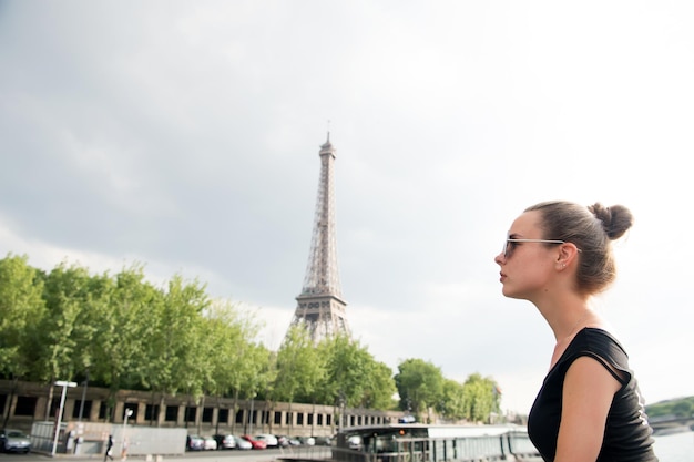 パリ、フランスのエッフェル塔を見ている女の子。ロマンチックな旅行のコンセプト