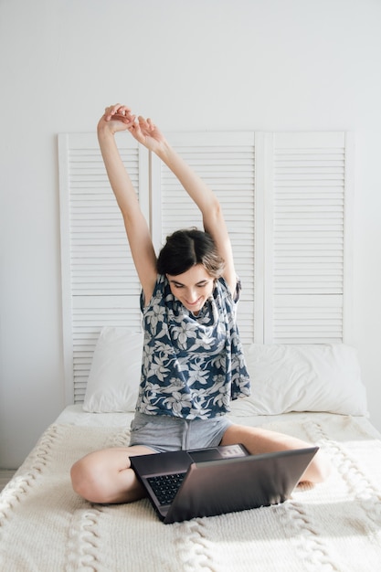 Girl looking at the laptop on the bed 