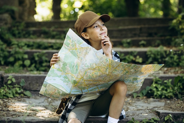 Girl looking at the map while walking in the forest