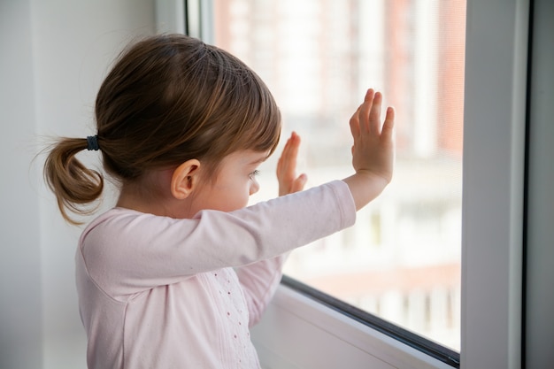 Girl looking outside through the window