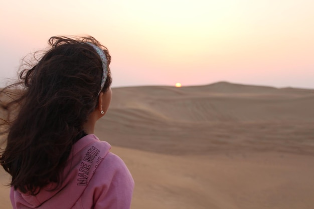デュバイス砂漠の夕暮れを見ている女の子