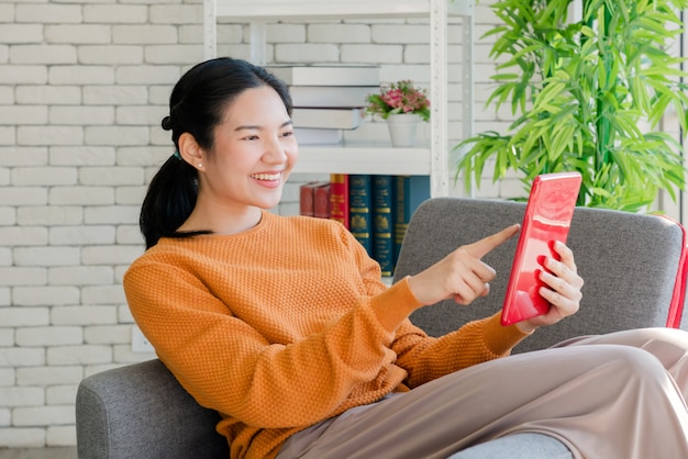 Girl looking a tablet on sofa at home