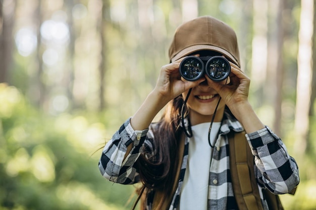 girl looking through binoculars in park