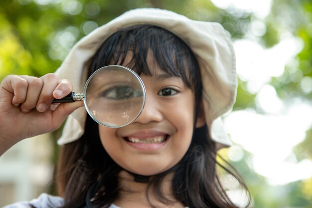 Girl looking through a magnifying glass