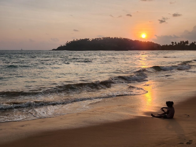 Girl looking towards the sea on sunset time