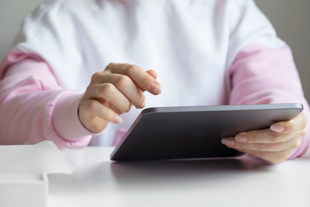 The girl looks at the new tablet, touches the screen with her finger.