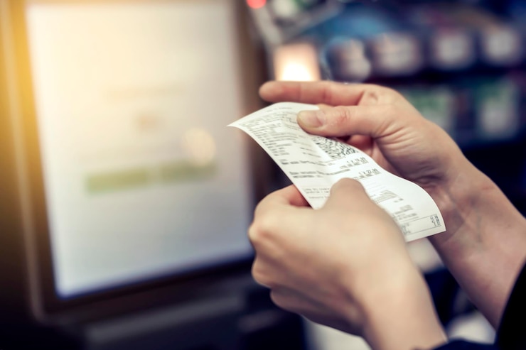 Photo the girl looks at the receipt in the store