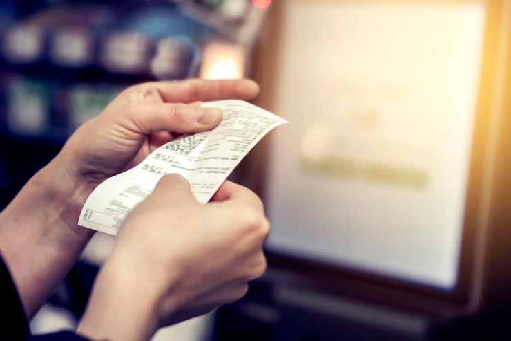 Photo the girl looks at the receipt in the store