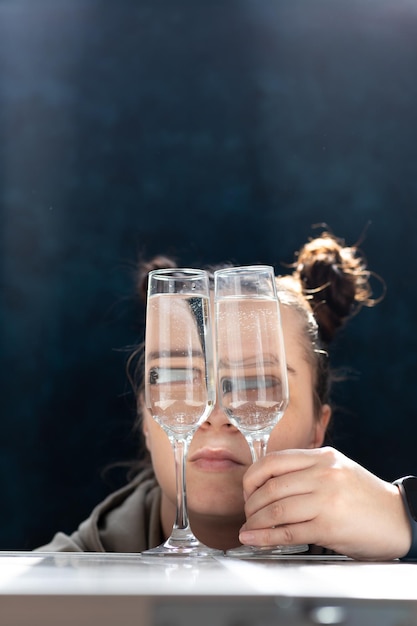 The girl looks through the glasses with a drink