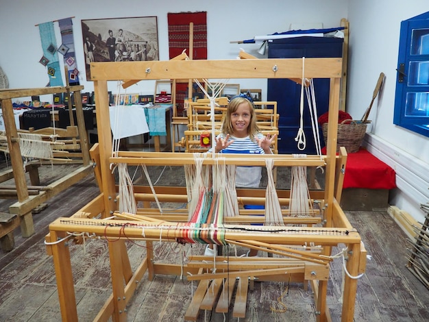 Girl loom and threads Antique equipment for the production of carpets clothing and woven household items The threads and yarns are stretched over the slats Trsic Loznica Serbia Ethno tourism