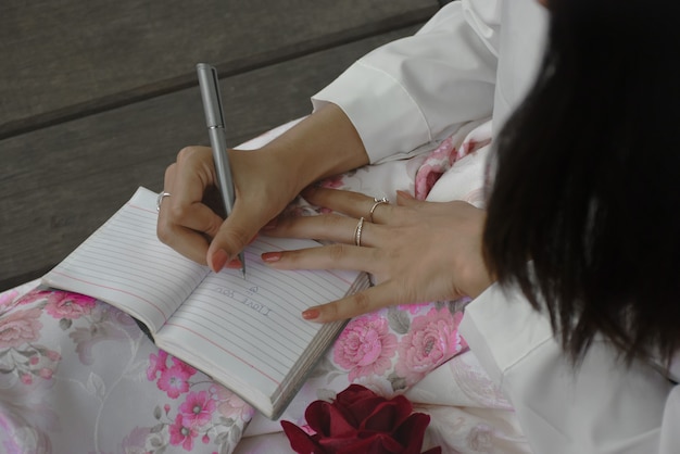 Girl in love writes a letter in a notebook.