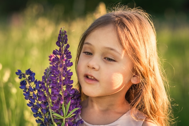 自然の中で少女とルピナスの花