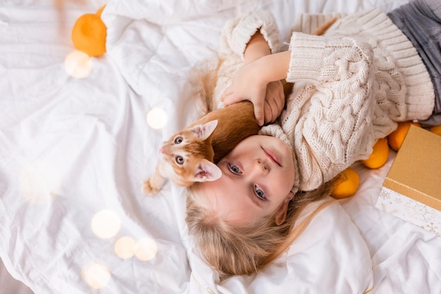 Photo a girl lying on a bed with a cat