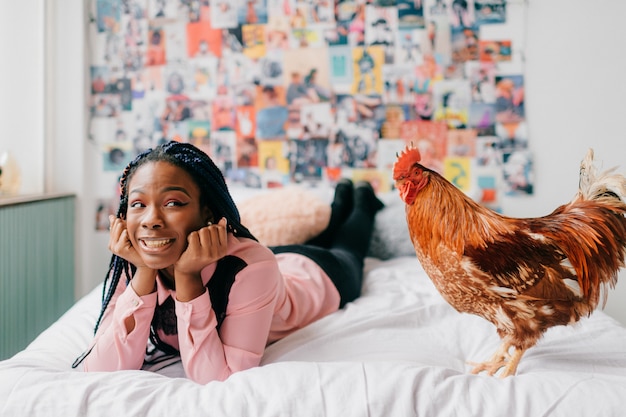 Girl lying in bed with a rooster