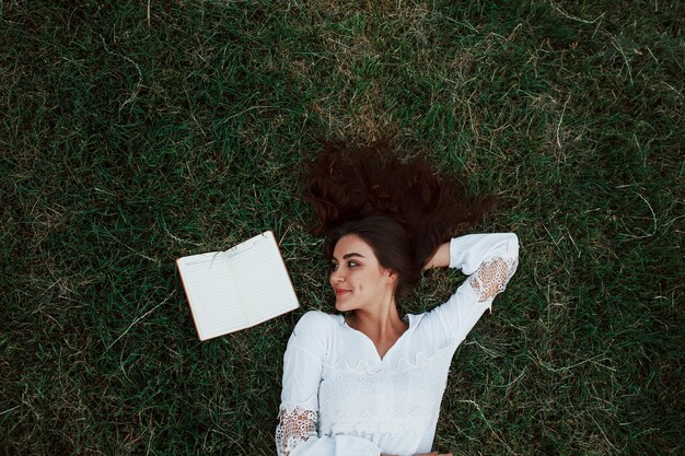 Girl lying down on the green grass