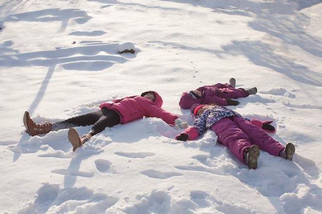 Foto ragazza sdraiata sulla terra coperta di neve