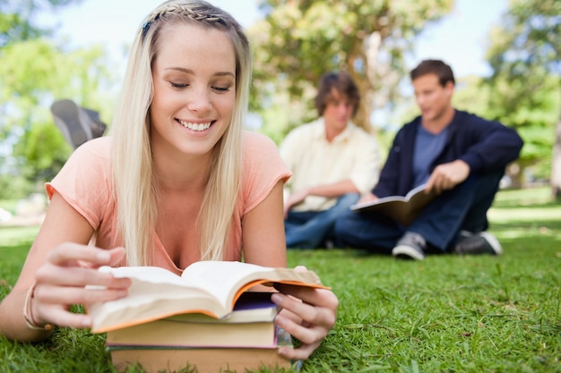 Girl lying while reading books in a park