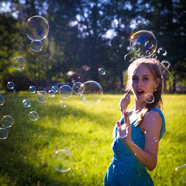 A girl makes big soap bubbles in the park