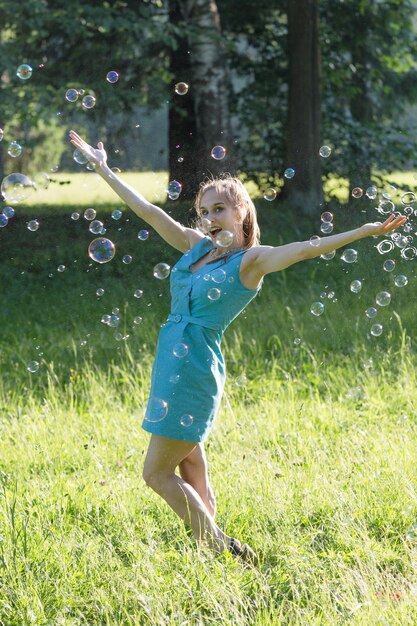 A girl makes big soap bubbles in the park