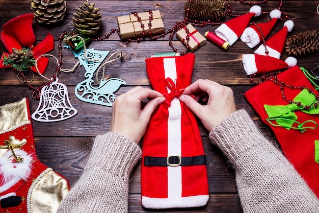 Foto la ragazza fa i regali di natale su un tavolo di legno scuro.