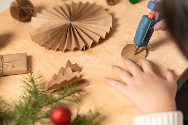 girl makes Christmas tree decorations out of paper with her own hands step 4