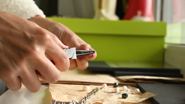 Girl makes jewelry with her hands.