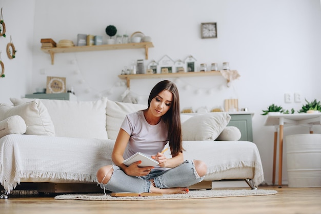 Photo girl makes notes in a notebook cozy home interior scandinavian kitchen interior