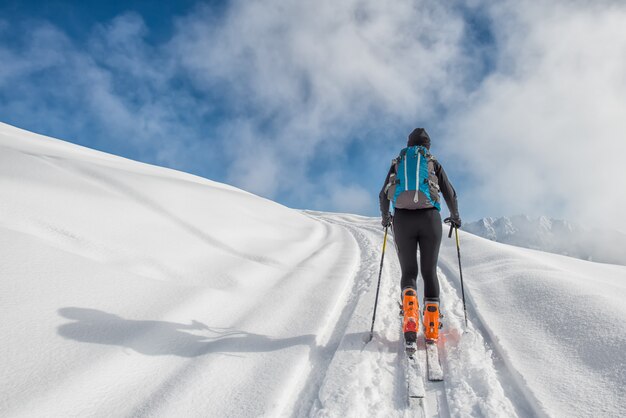 Una ragazza fa sci alpinismo