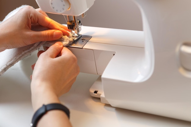 Girl makes stitch on cloth on sewing machine