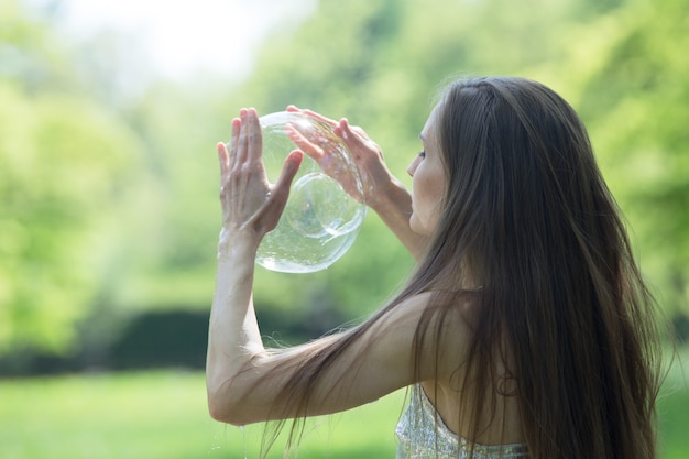 A girl makes vibrant soap bubbles in the park