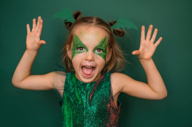 초록색 배경 에 드래곤 의 형태 로 메이크업 을 한 소녀