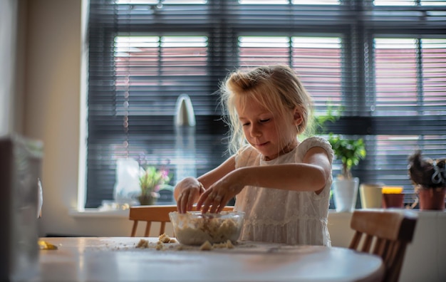 Photo girl making food on table at home