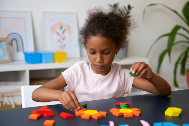 girl making puzzle at table medium shot