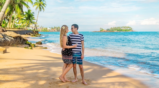 Girl and man on the beach by the ocean