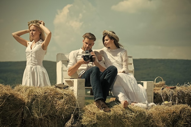 Girl and man watching photos in camera on bench