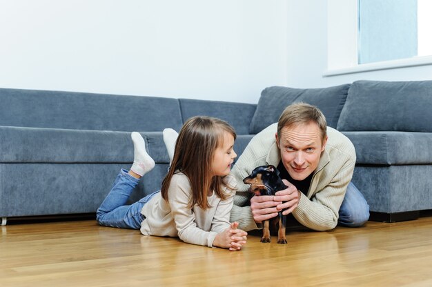 La ragazza e l'uomo con il cucciolo sono sul pavimento nella stanza.