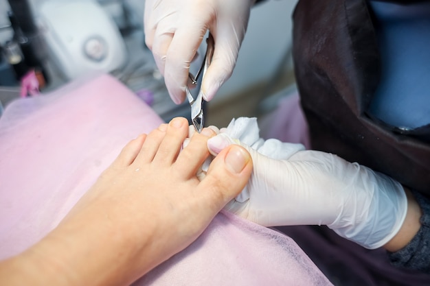 The girl master of nail service works with the client