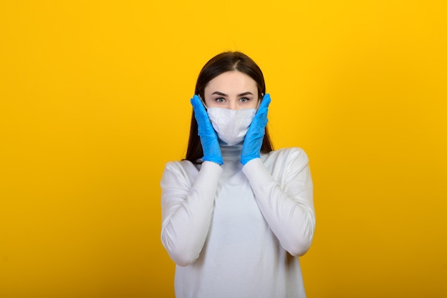 Girl in medical gloves dress protective mask on her face