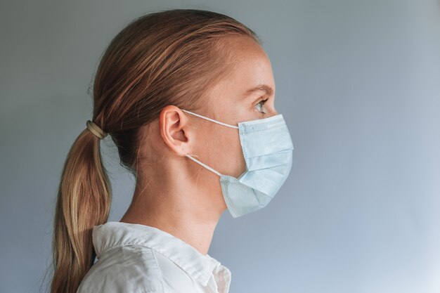 Una ragazza con una maschera medica. copia spazio