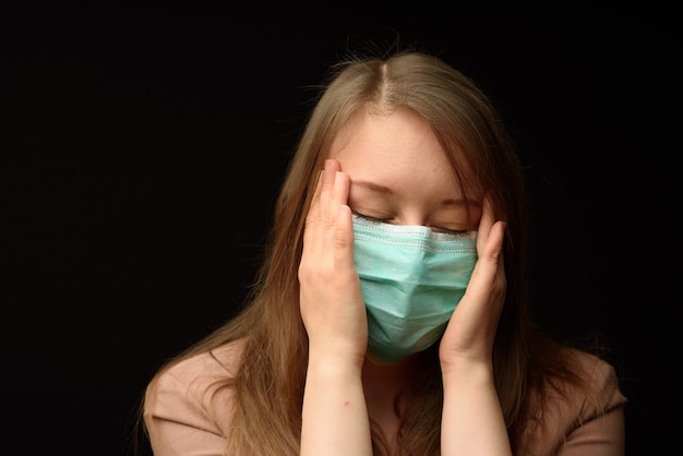 The girl in the medical mask shows the symptoms of the disease.