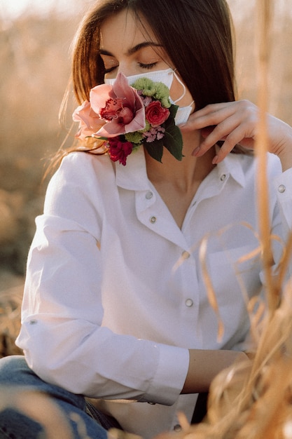 Girl in a medical mask with flowers