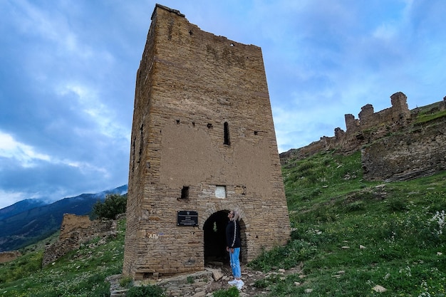 A girl at the medieval defensive towers in the ancient village of Goor Russia Dagestan 2021