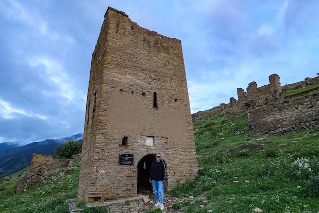 A girl at the medieval defensive towers in the ancient village of Goor Russia Dagestan 2021