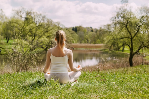 A girl meditates in the Lotus position in the fresh air in the Park.