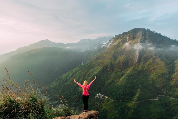 Foto la ragazza incontra l'alba in montagna. ragazza in viaggio in sri lanka. sport di montagna. atleta felice finale. turismo di montagna. passeggiata. il viaggio in montagna. camminata nordica