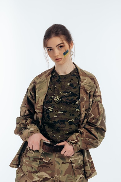 Ragazza in uniforme militare bandiera ucraina dell'ucraina sul volto guerra in ucraina bucha su sfondo bianco