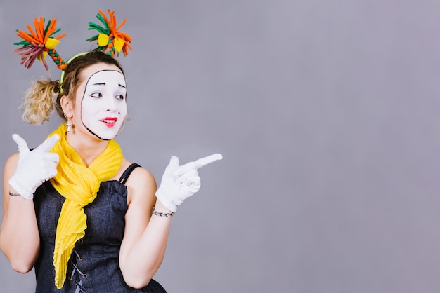 Girl mime posing near a gray 