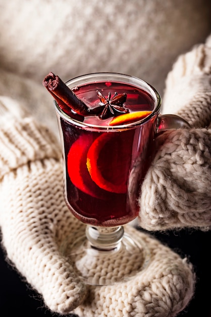 Photo girl in mittens hold glass of mulled wine